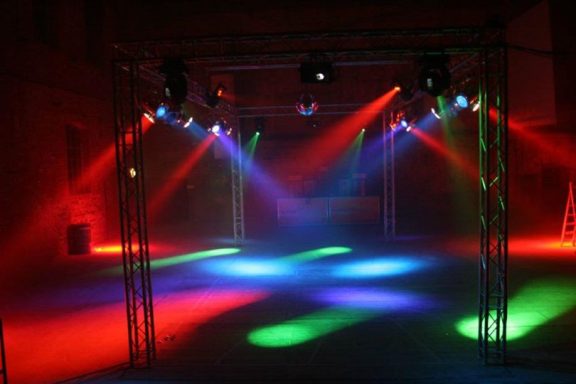 Lichtinstallation mit bunten Strahlen in einem dunklen Raum.