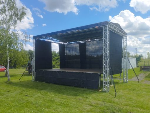 Konzertbühne mieten Bühne im Freien mit schwarzem Vorhang und blauen Himmel im Hintergrund.