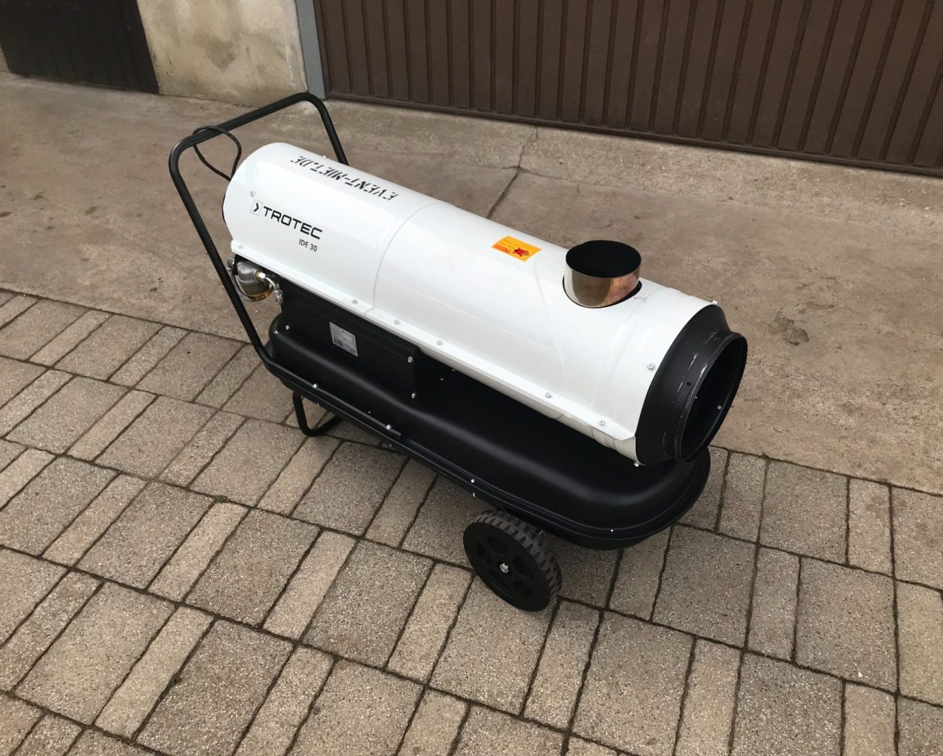 Mobiler Heizlüfter auf Rädern mit schwenkbarem Auslass und schwarzem Gestell.