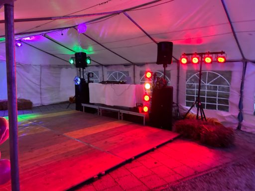Festzelt mit DJ-Pult, bunten Lichtern und Lautsprechern.