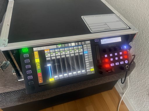 Mischpult mit digitalen Reglern und LED-Anzeigen für Audioverwaltung.